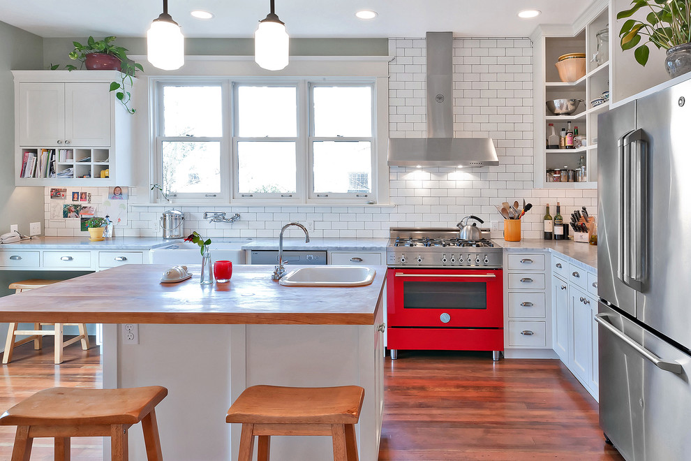 Inspiration for a mid-sized country u-shaped separate kitchen in Seattle with a farmhouse sink, shaker cabinets, white cabinets, wood benchtops, white splashback, subway tile splashback, stainless steel appliances, carpet, with island, brown floor and brown benchtop.