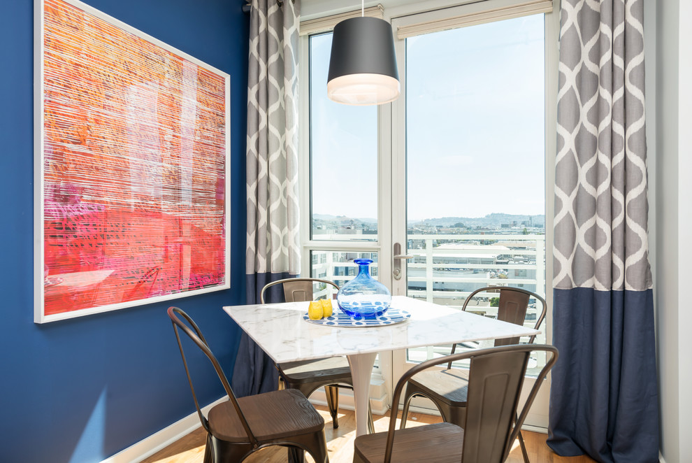 This is an example of a mid-sized transitional open plan dining in San Francisco with blue walls, dark hardwood floors and no fireplace.