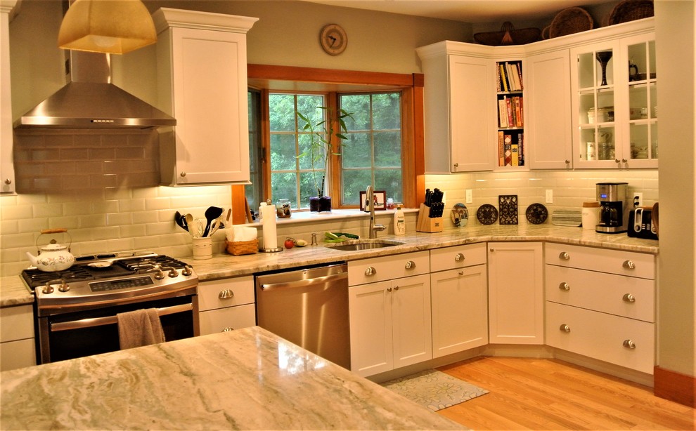 Kitchen - transitional light wood floor kitchen idea in Boston with an undermount sink, shaker cabinets, white cabinets, quartzite countertops, white backsplash, subway tile backsplash, stainless steel appliances and an island