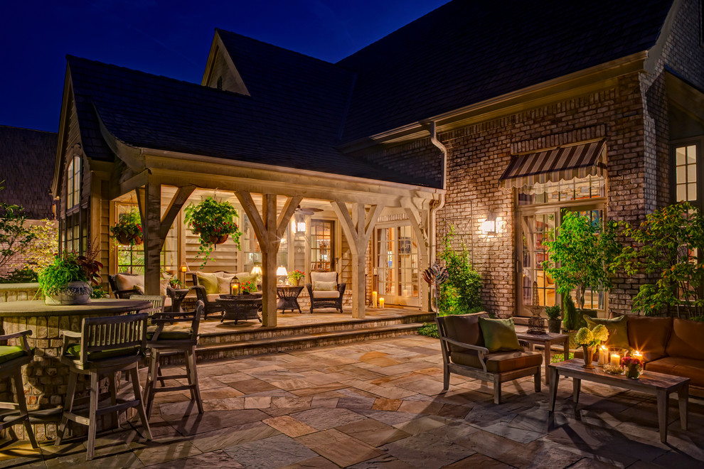 Design ideas for a large traditional backyard patio in Chicago with a pergola and natural stone pavers.