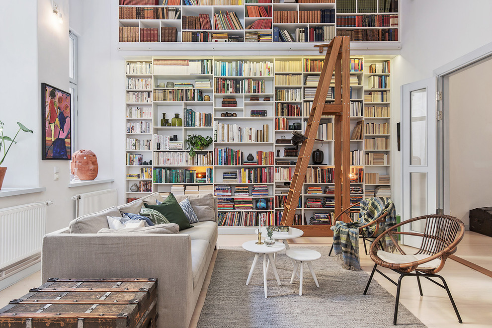 Design ideas for an expansive transitional open concept living room in Stockholm with a library, white walls, light hardwood floors, no fireplace and no tv.