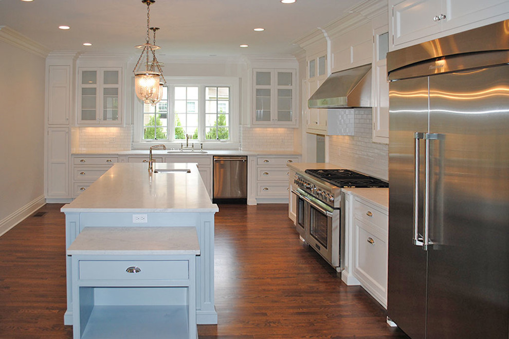 Example of a large transitional l-shaped dark wood floor and brown floor eat-in kitchen design with an undermount sink, shaker cabinets, white cabinets, stainless steel appliances and an island