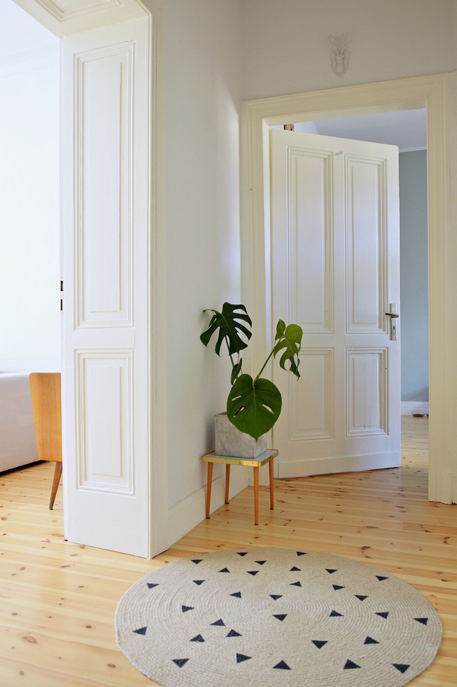This is an example of a mid-sized transitional hallway in Dusseldorf with white walls and light hardwood floors.
