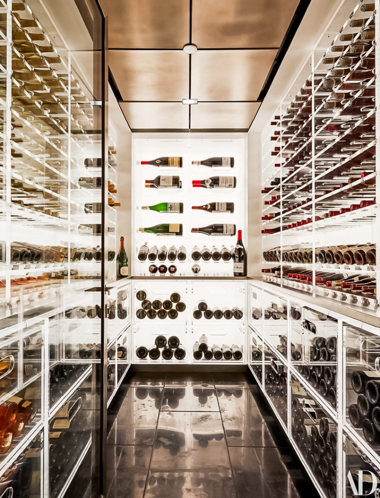 This is an example of a large modern wine cellar in New York with ceramic floors, storage racks and black floor.