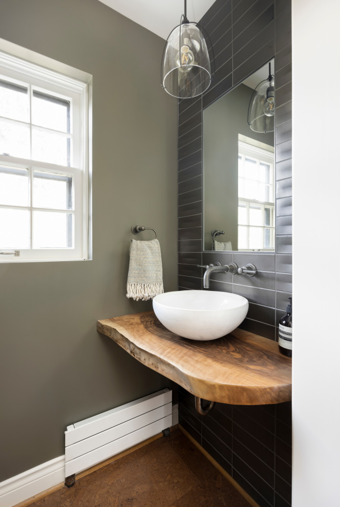 Cette image montre un petit WC et toilettes traditionnel en bois brun avec un placard sans porte, un carrelage noir, des carreaux de céramique, un sol en liège, une vasque, un plan de toilette en bois, un sol marron, un plan de toilette marron et meuble-lavabo suspendu.
