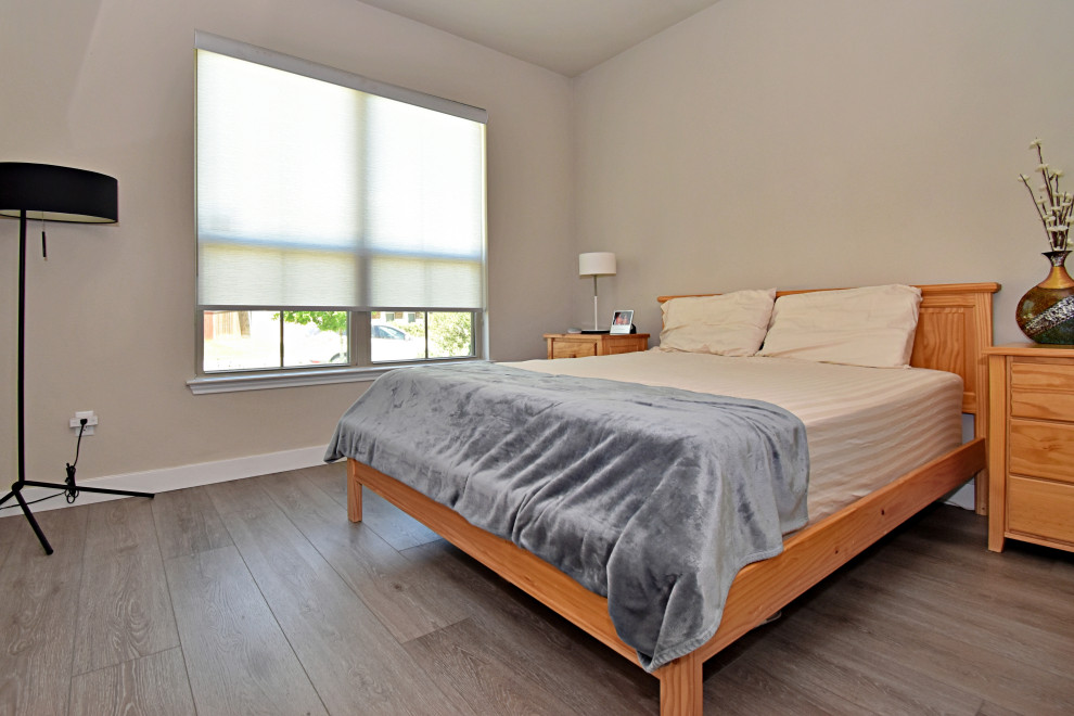 Cette image montre une chambre parentale design de taille moyenne avec un mur blanc, un sol en vinyl, un sol gris et un plafond voûté.