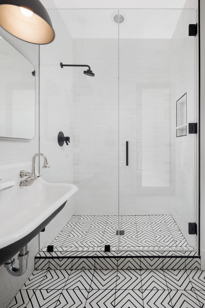 Photo of a mid-sized transitional kids bathroom in Phoenix with shaker cabinets, black cabinets, an open shower, a one-piece toilet, white tile, subway tile, white walls, cement tiles, a wall-mount sink, engineered quartz benchtops, white floor and a hinged shower door.
