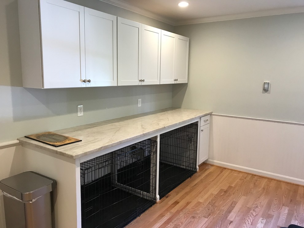 Photo of a traditional utility room in Baltimore with a farmhouse sink, recessed-panel cabinets, white cabinets, quartzite benchtops, light hardwood floors and a side-by-side washer and dryer.