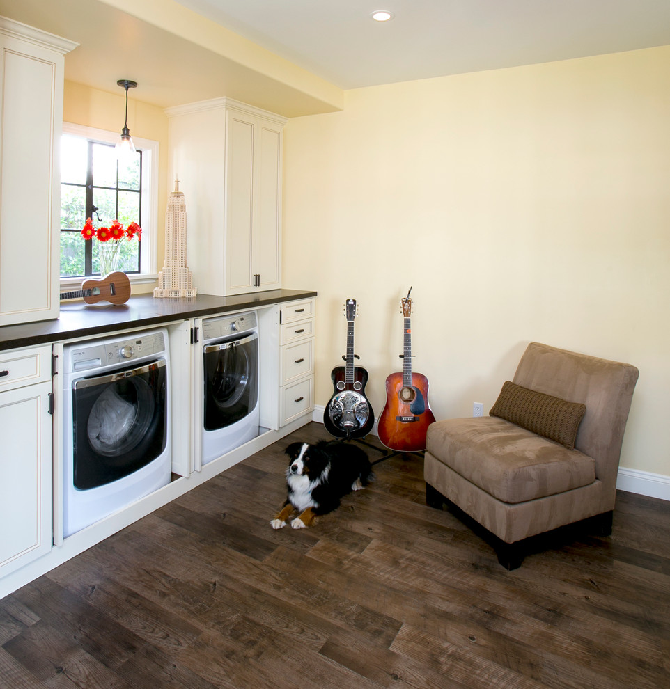 Mid-sized transitional u-shaped utility room in San Francisco with recessed-panel cabinets, white cabinets, quartz benchtops, yellow walls, linoleum floors and a concealed washer and dryer.