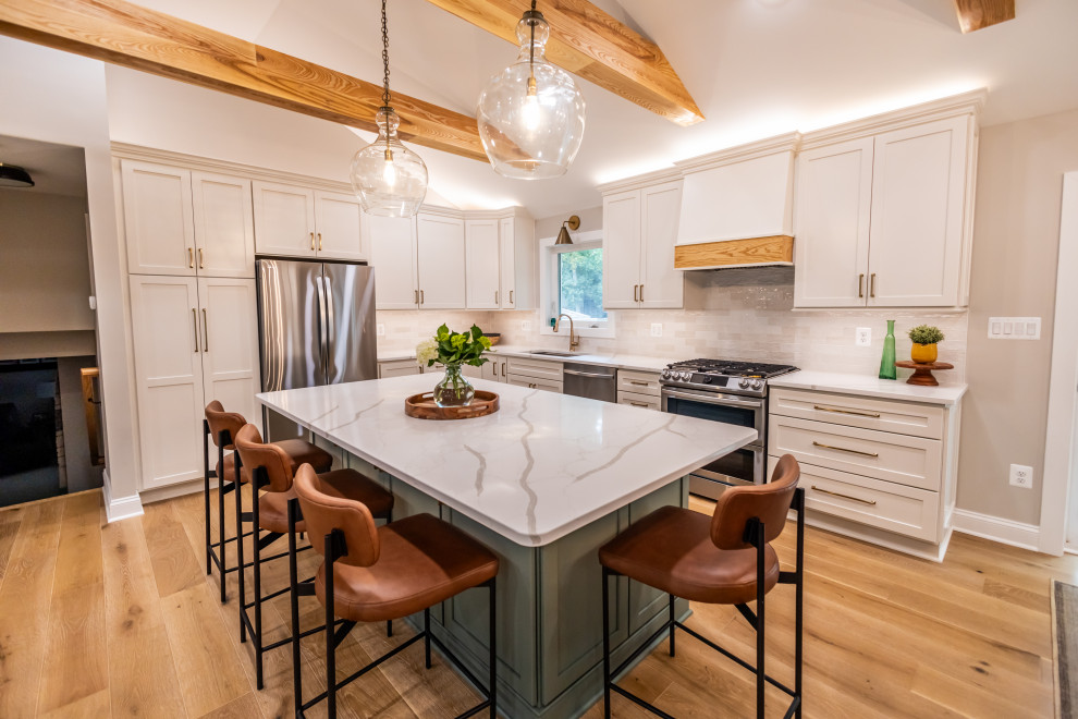 Eat-in kitchen - large transitional l-shaped light wood floor, brown floor and exposed beam eat-in kitchen idea in DC Metro with an undermount sink, shaker cabinets, quartz countertops, white backsplash, porcelain backsplash, stainless steel appliances, an island and white countertops