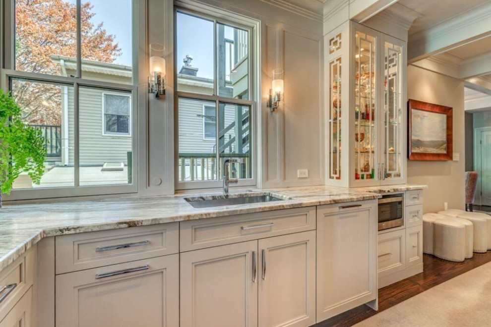 Example of a large transitional u-shaped medium tone wood floor and brown floor eat-in kitchen design in Boston with an undermount sink, shaker cabinets, white cabinets, marble countertops, gray backsplash, marble backsplash, stainless steel appliances, an island and gray countertops