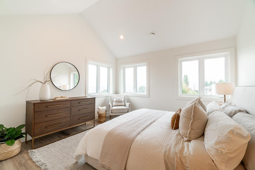 Example of a mid-sized transitional master laminate floor, brown floor and vaulted ceiling bedroom design in Vancouver with white walls and no fireplace