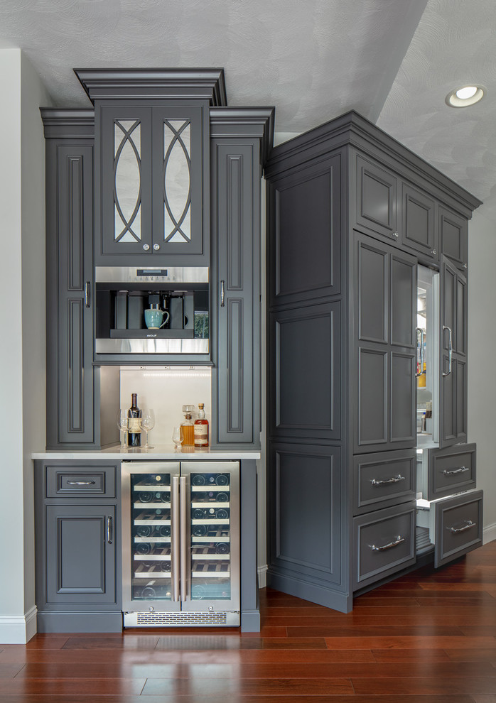Inspiration for a small traditional single-wall home bar in Boston with grey cabinets, quartz benchtops, white benchtop, no sink, white splashback, beaded inset cabinets and dark hardwood floors.