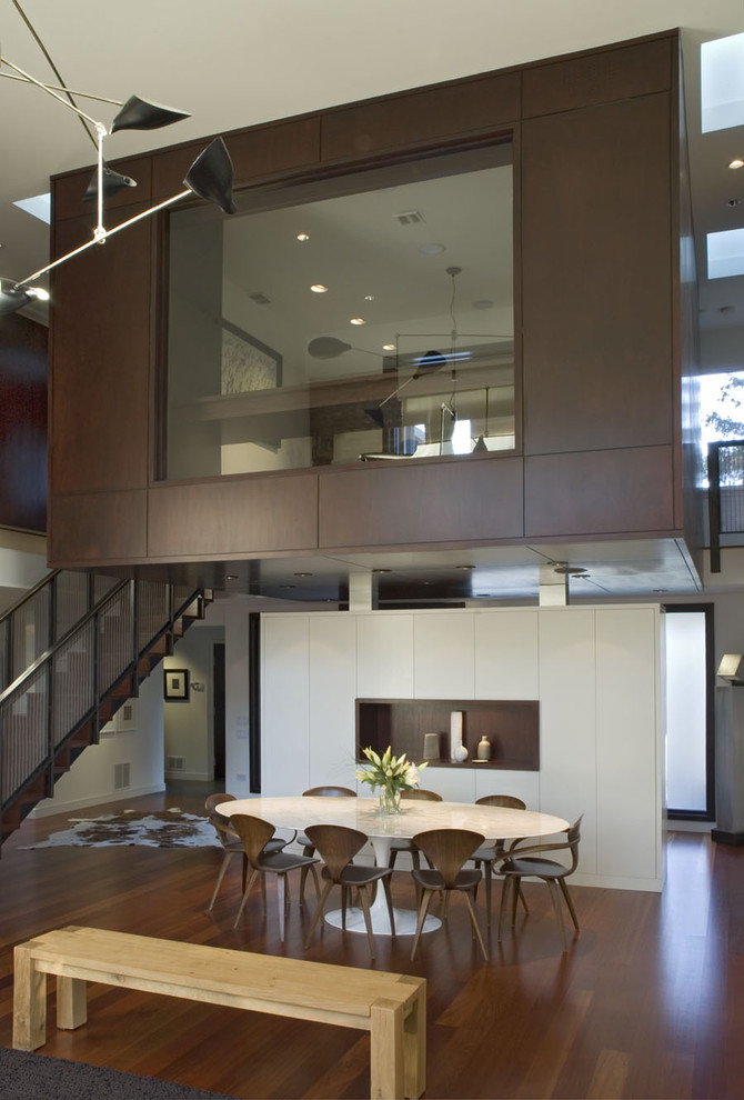 Contemporary dining room in Chicago with white walls and dark hardwood floors.