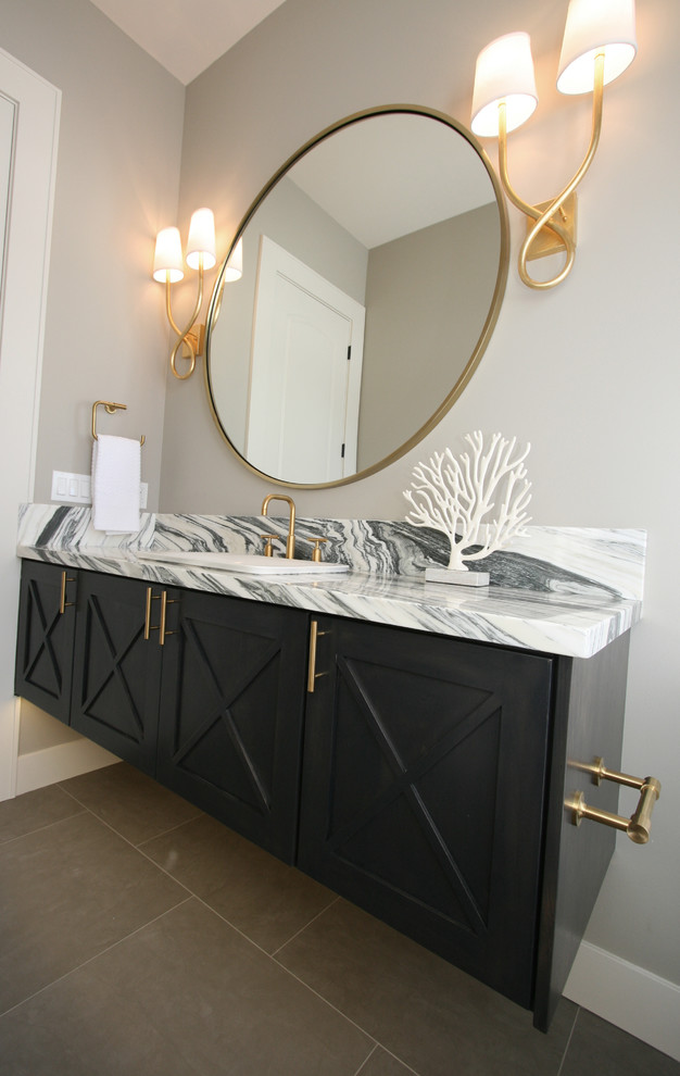 Photo of a large transitional powder room in Seattle with furniture-like cabinets, black cabinets, a two-piece toilet, gray tile, porcelain tile, grey walls, porcelain floors, a vessel sink and marble benchtops.