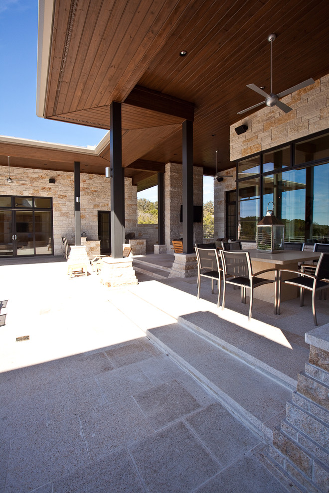 Photo of a contemporary patio in Austin with a roof extension.