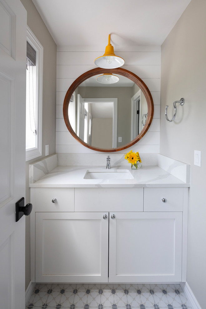 Пример оригинального дизайна: ванная комната среднего размера в стиле кантри с фасадами в стиле шейкер, белыми фасадами, ванной в нише, душем в нише, белой плиткой, мраморной плиткой, белыми стенами, полом из цементной плитки, душевой кабиной, врезной раковиной, столешницей из искусственного кварца, белым полом, шторкой для ванной, белой столешницей, тумбой под одну раковину, встроенной тумбой и стенами из вагонки