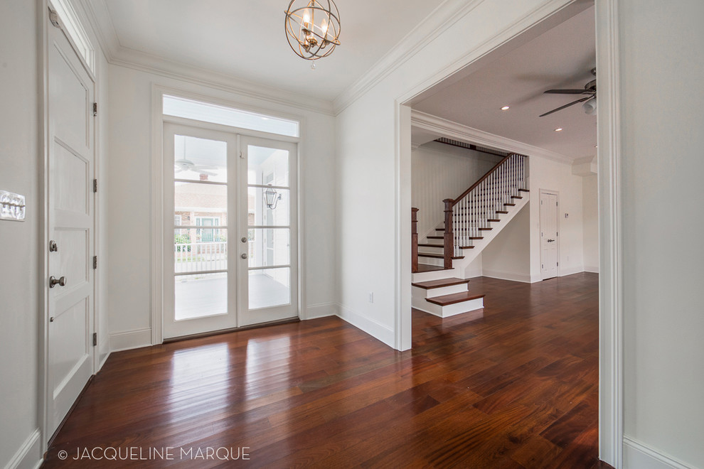 Large transitional foyer in New Orleans with white walls, dark hardwood floors, a single front door and a white front door.