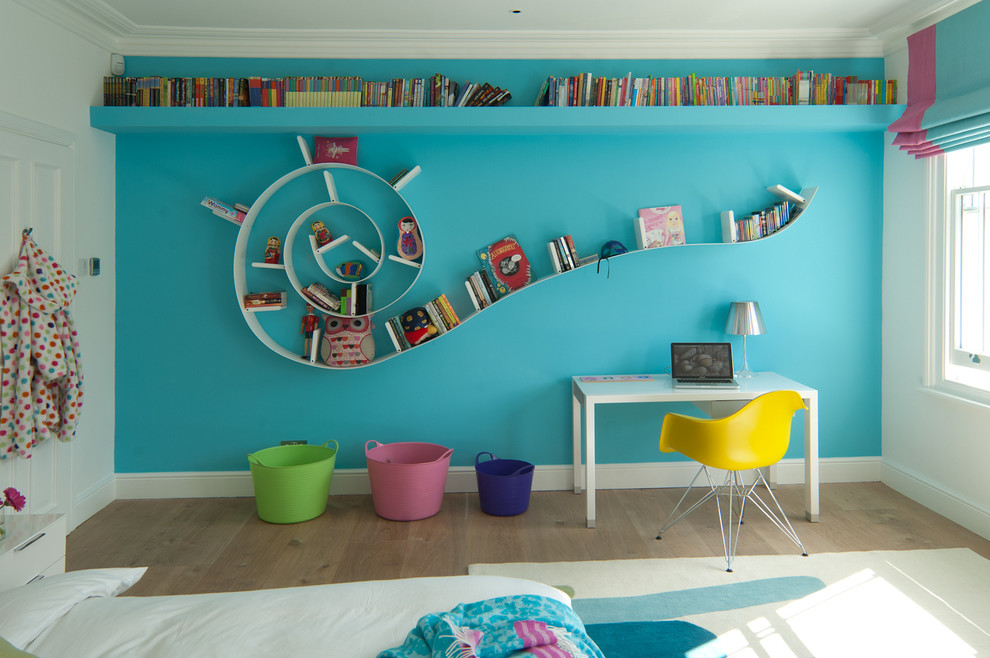 This is an example of a contemporary gender-neutral kids' study room for kids 4-10 years old in Kent with medium hardwood floors and multi-coloured walls.