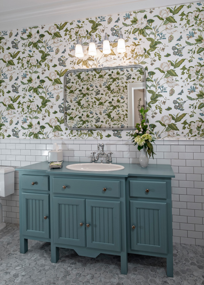 Photo of a tropical bathroom in Miami with shaker cabinets, blue cabinets, white tile, subway tile, multi-coloured walls, mosaic tile floors, a drop-in sink, wood benchtops, grey floor, blue benchtops, a single vanity and a freestanding vanity.