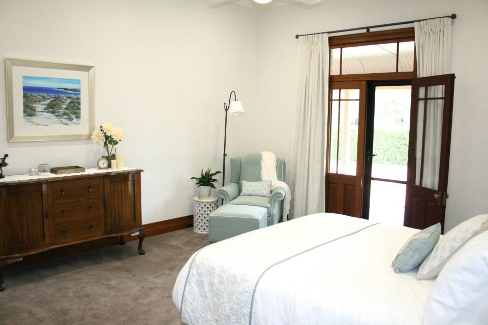 This is an example of a large contemporary master bedroom in Sydney with beige walls and carpet.