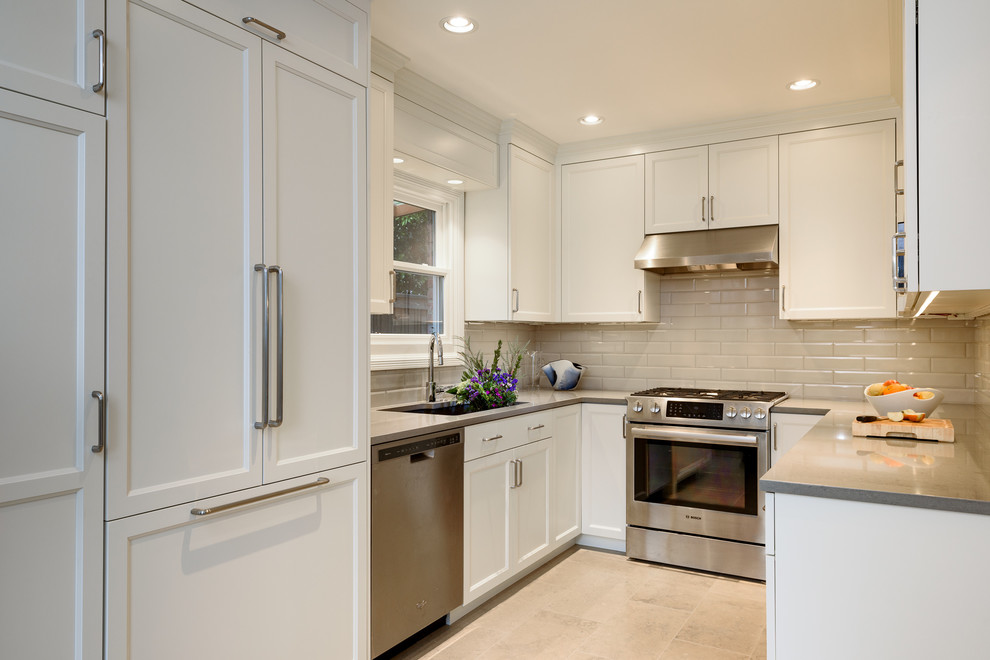 This is an example of a small transitional u-shaped separate kitchen in Seattle with an undermount sink, recessed-panel cabinets, white cabinets, quartz benchtops, grey splashback, ceramic splashback, stainless steel appliances, limestone floors, no island, grey floor and grey benchtop.
