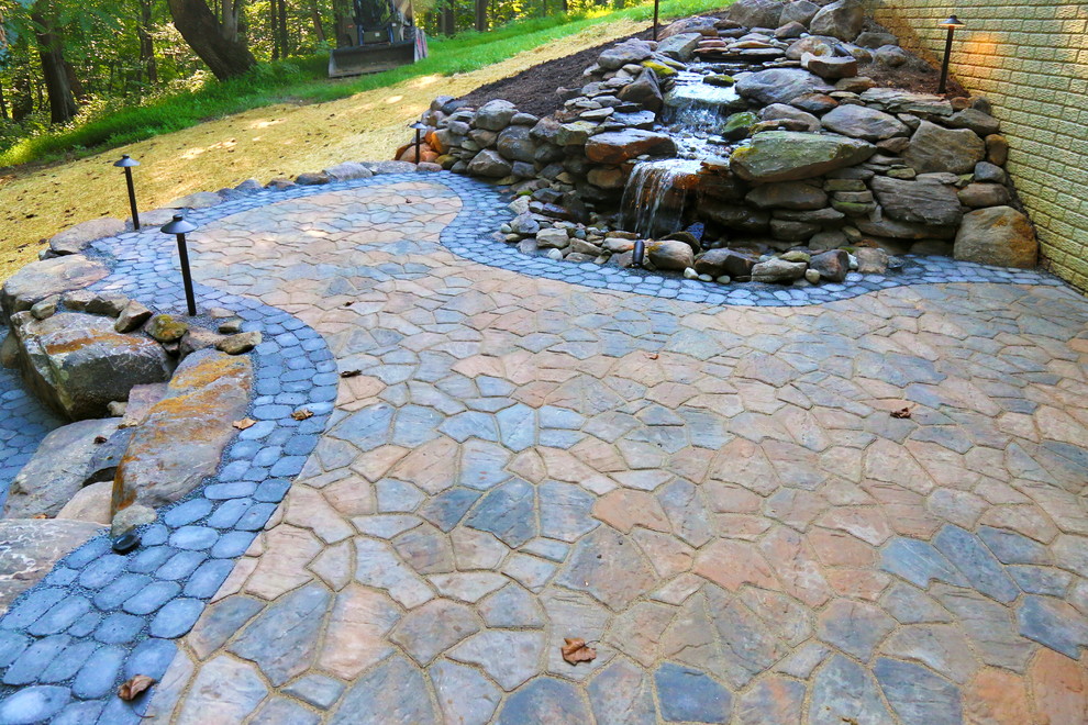 Mid-sized country backyard patio in DC Metro with a fire feature, concrete pavers and no cover.