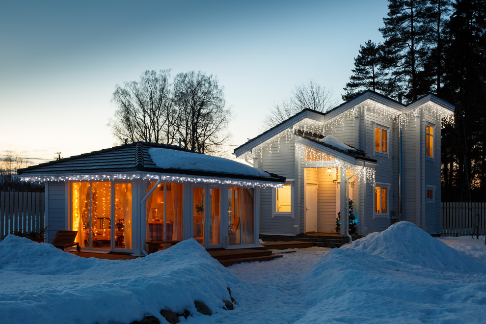 Idee per la facciata di una casa blu scandinava a piani sfalsati di medie dimensioni con rivestimento in pietra, copertura in tegole e tetto nero