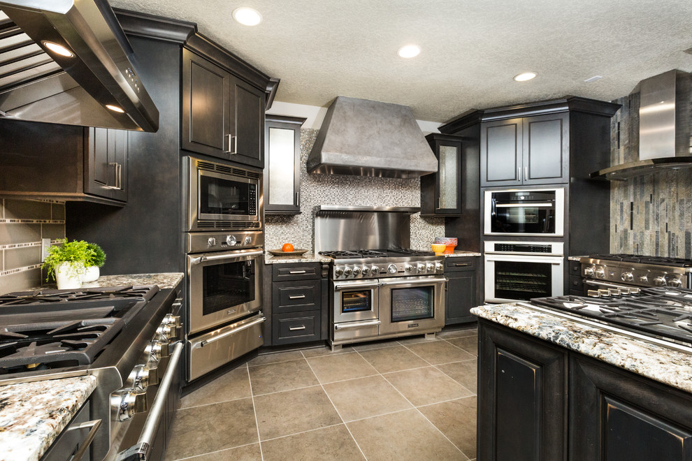 Inspiration for a large transitional u-shaped porcelain tile eat-in kitchen remodel in Albuquerque with granite countertops, glass tile backsplash, stainless steel appliances, an island, recessed-panel cabinets, black cabinets and gray backsplash