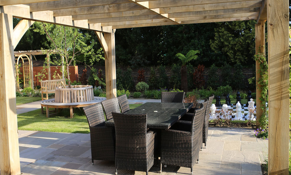 This is an example of a mid-sized contemporary backyard patio in London with natural stone pavers.