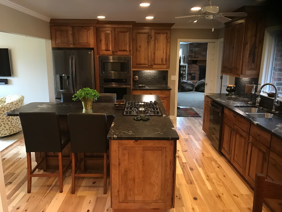 Eat-in kitchen - mid-sized rustic l-shaped eat-in kitchen idea with an undermount sink, raised-panel cabinets, medium tone wood cabinets, granite countertops and an island