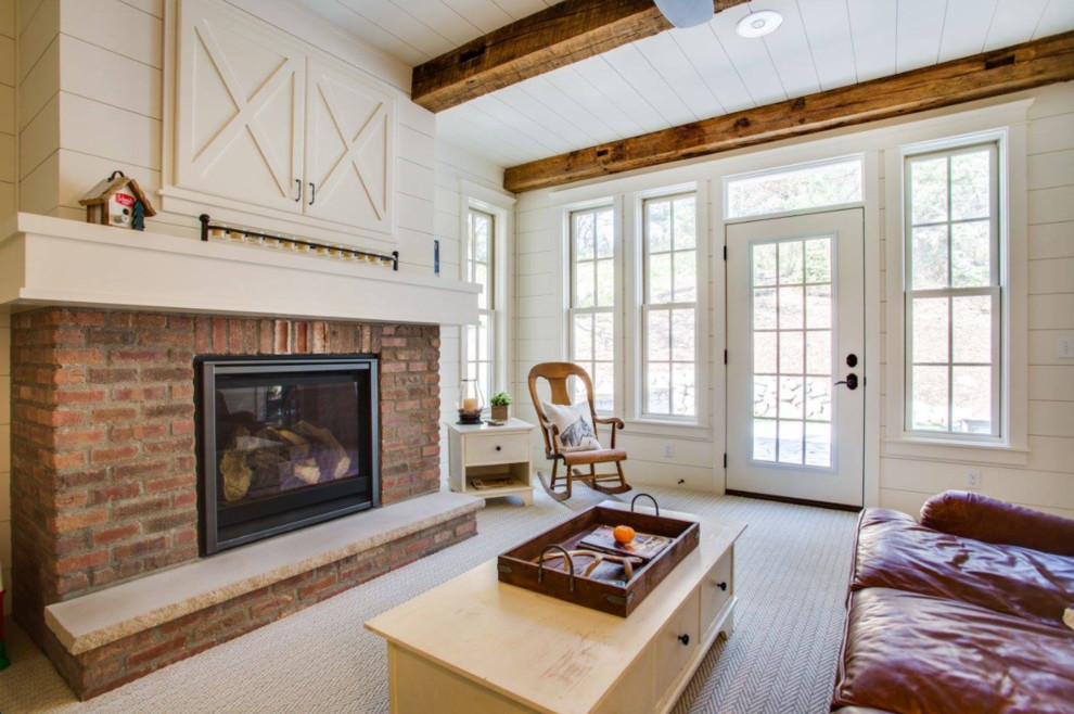 Mid-sized country enclosed family room in Minneapolis with white walls, carpet, a standard fireplace, a brick fireplace surround and a concealed tv.