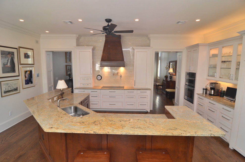 Inspiration for a mid-sized transitional u-shaped dark wood floor eat-in kitchen remodel in Orlando with a drop-in sink, raised-panel cabinets, white cabinets, granite countertops, black backsplash, subway tile backsplash, stainless steel appliances and no island
