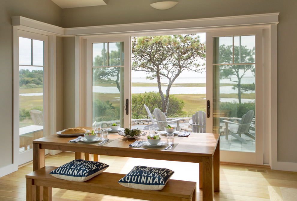 This is an example of a mid-sized beach style separate dining room in Boston with grey walls, light hardwood floors, no fireplace and brown floor.