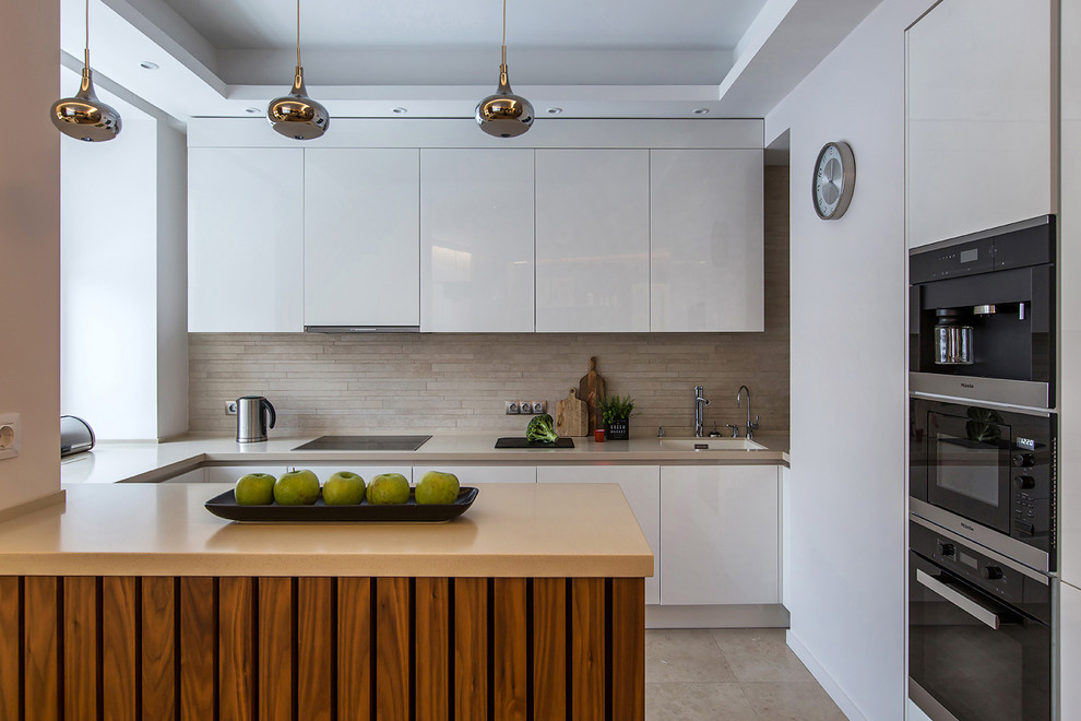Inspiration for a contemporary u-shaped open plan kitchen in Moscow with an undermount sink, flat-panel cabinets, white cabinets, beige splashback, stainless steel appliances, a peninsula and beige floor.