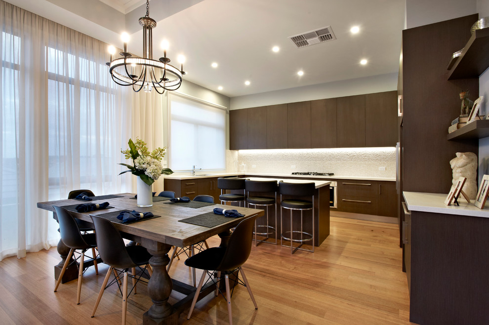Contemporary u-shaped eat-in kitchen in Melbourne with flat-panel cabinets and dark wood cabinets.