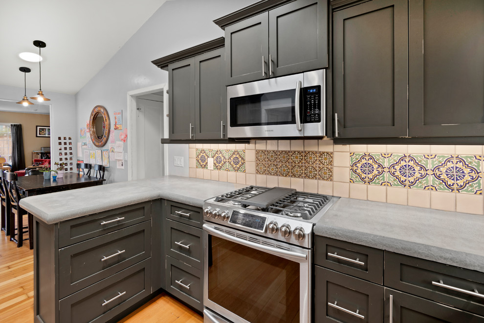 Design ideas for a small traditional u-shaped kitchen in San Francisco with an undermount sink, shaker cabinets, distressed cabinets, concrete benchtops, ceramic splashback, stainless steel appliances, medium hardwood floors, brown floor and grey benchtop.