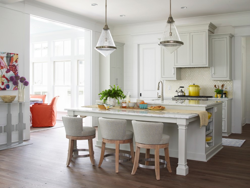 Design ideas for a beach style galley open plan kitchen in Charleston with an undermount sink, recessed-panel cabinets, grey cabinets, marble benchtops, white splashback, ceramic splashback, stainless steel appliances and medium hardwood floors.
