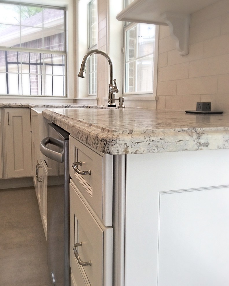 Eat-in kitchen - mid-sized transitional u-shaped ceramic tile eat-in kitchen idea in Houston with a farmhouse sink, recessed-panel cabinets, white cabinets, granite countertops, white backsplash, stone tile backsplash, stainless steel appliances and an island