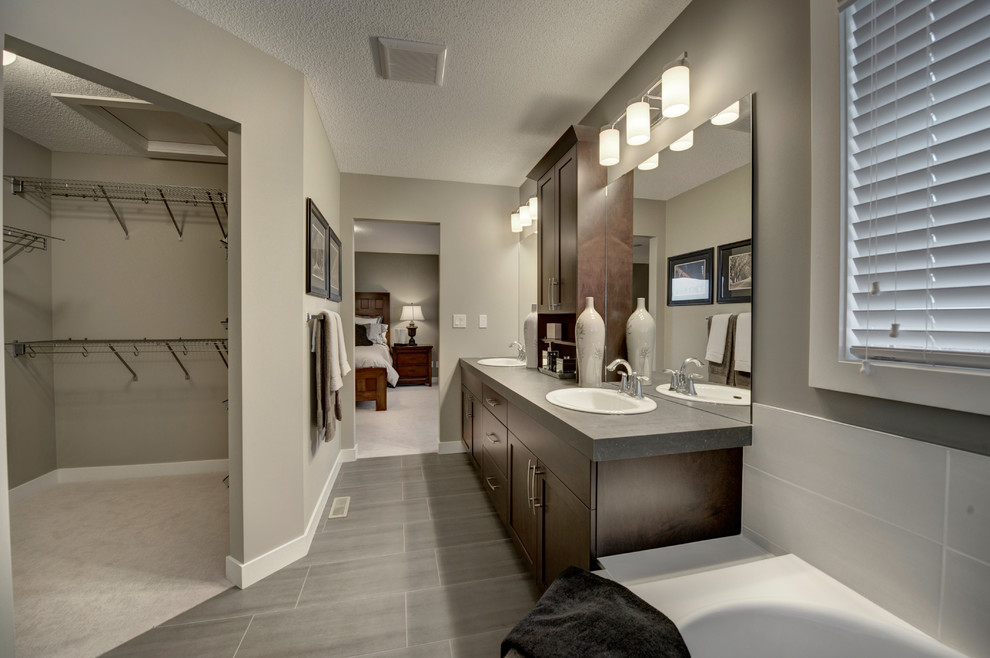 Large transitional master bathroom in Edmonton with an integrated sink, raised-panel cabinets, dark wood cabinets, laminate benchtops, an alcove shower, a one-piece toilet, brown tile, ceramic tile, grey walls, ceramic floors and a drop-in tub.