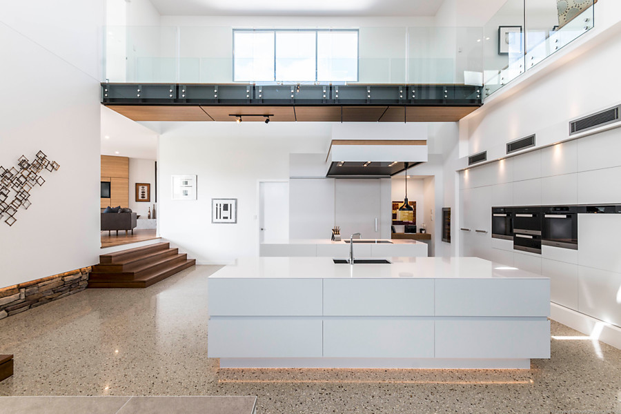 Design ideas for an expansive contemporary u-shaped kitchen in Gold Coast - Tweed with concrete floors, a double-bowl sink, black appliances and multiple islands.