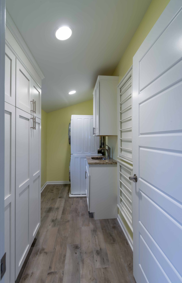 Mid-sized traditional galley utility room in Chicago with a drop-in sink, flat-panel cabinets, white cabinets, marble benchtops, white splashback, ceramic splashback, yellow walls, light hardwood floors, a side-by-side washer and dryer, brown floor, white benchtop, wallpaper and wallpaper.