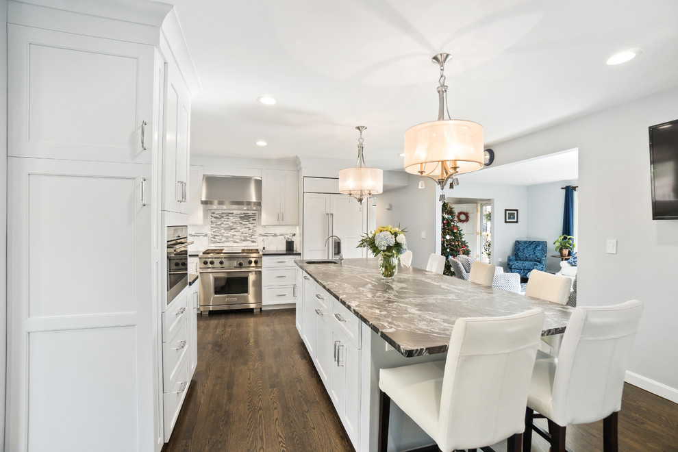 Inspiration for an expansive transitional u-shaped eat-in kitchen in Providence with an undermount sink, recessed-panel cabinets, white cabinets, granite benchtops, white splashback, marble splashback, stainless steel appliances, dark hardwood floors, with island and brown floor.