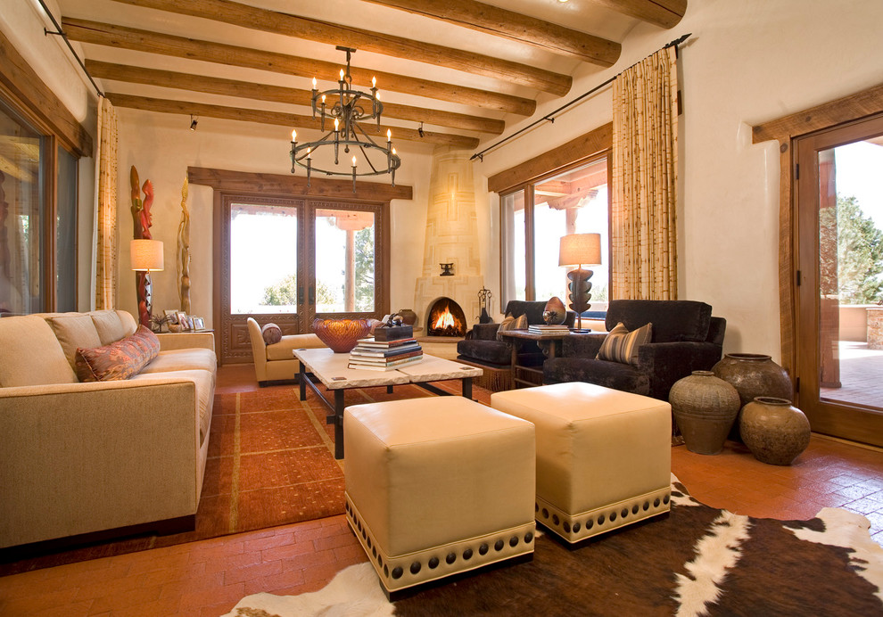 This is an example of a large mediterranean formal open concept living room in Albuquerque with beige walls, brick floors, a corner fireplace and no tv.