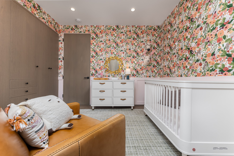 Cette image montre une chambre de bébé fille design de taille moyenne avec un mur multicolore, un sol en bois brun et un sol marron.