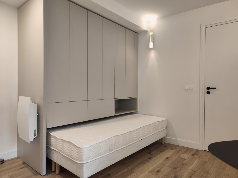 Idee per una piccola camera degli ospiti minimalista con pareti grigie, parquet chiaro e pavimento beige