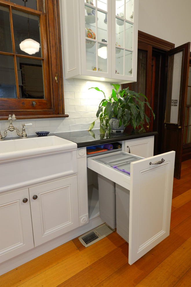 Inspiration for an expansive victorian u-shaped eat-in kitchen in Newcastle - Maitland with a farmhouse sink, recessed-panel cabinets, white cabinets, granite benchtops, white splashback, subway tile splashback, medium hardwood floors and with island.