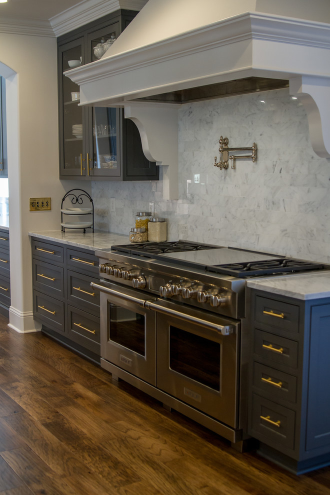 Inspiration for a transitional medium tone wood floor and brown floor eat-in kitchen remodel with beaded inset cabinets, gray cabinets, white backsplash, paneled appliances, an island and white countertops