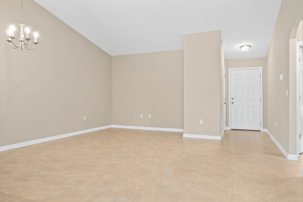 Photo of a mid-sized traditional open concept living room in Orlando with beige walls, ceramic floors and beige floor.
