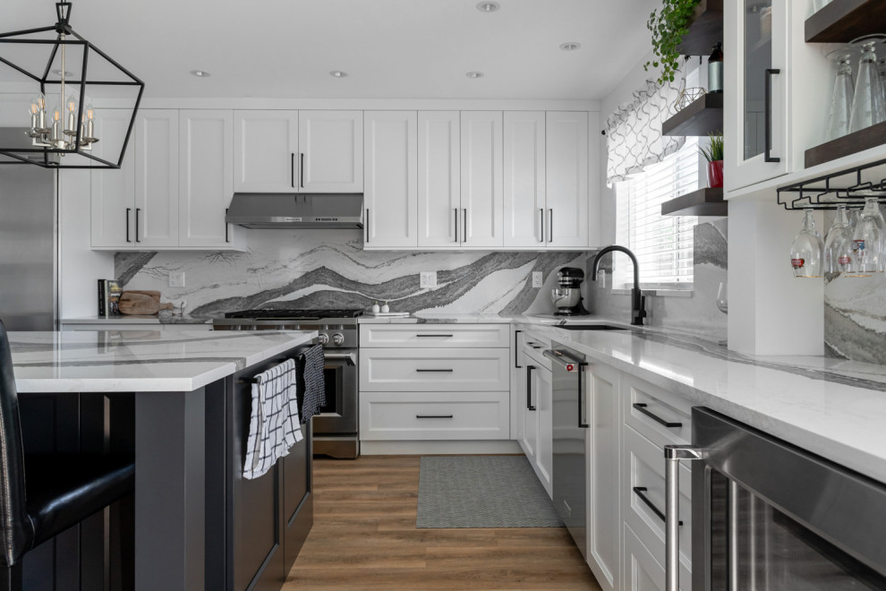 Mid-sized transitional u-shaped medium tone wood floor and brown floor eat-in kitchen photo with an undermount sink, recessed-panel cabinets, white cabinets, quartz countertops, white backsplash, stone slab backsplash, stainless steel appliances, an island and white countertops